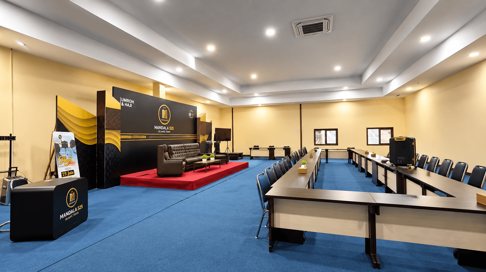Ruang pertemuan Mandala 525 dengan meja dan panggung presentasi